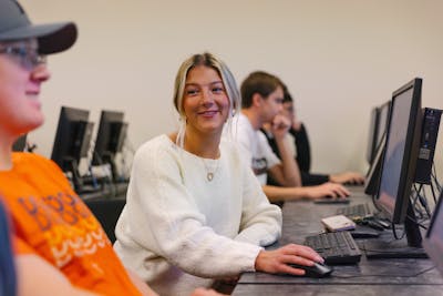 A student in a computer lab working on a desktop computer.