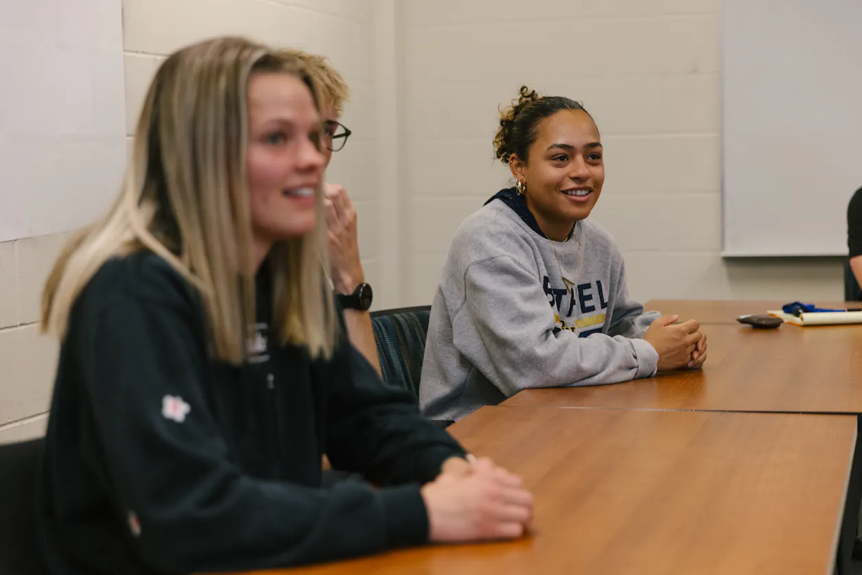 Bethel University students smiling and talking during a classroom session.