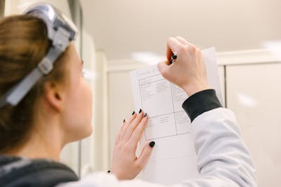 Student focused on writing notes during a lab session.