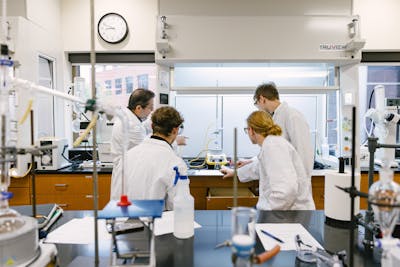 Professor instructing students in a chemistry lab.