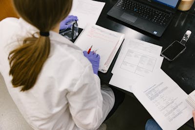 Overhead view of students taking notes in a lab.