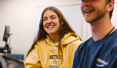 smiling girl in yellow sweatshirt 