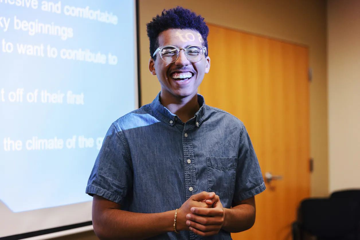 student smiling in front of board
