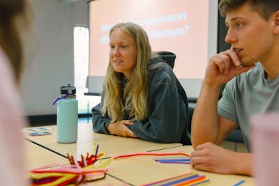 Students engaging in a creative classroom activity, using colorful craft materials.