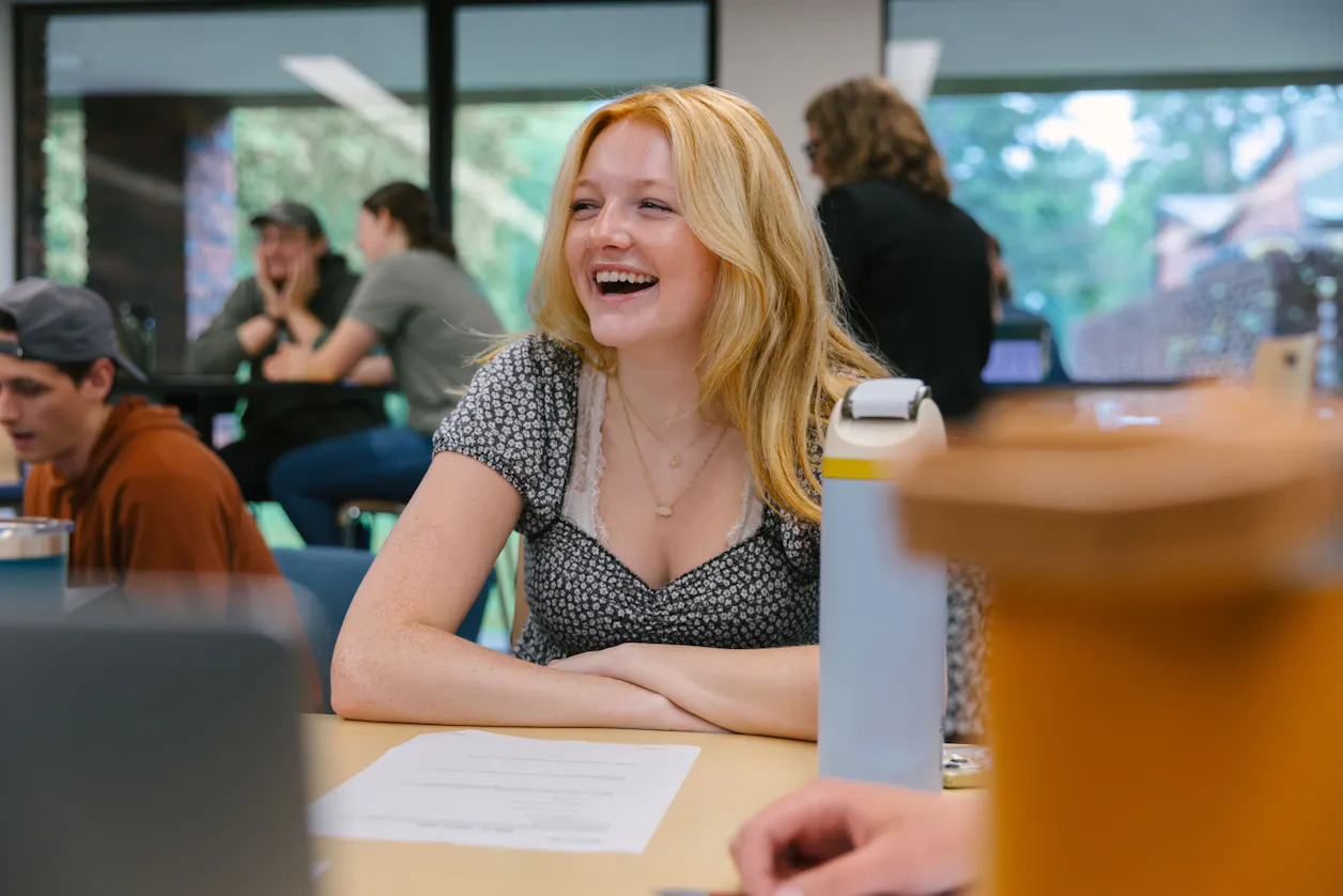 A smiling student participates in a lively classroom discussion at Bethel University.