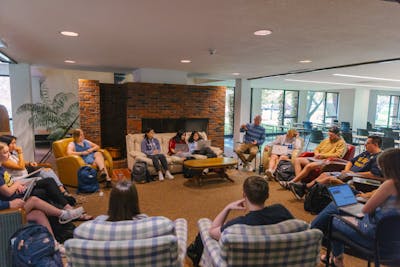 Students and a professor sit in a cozy circle for a discussion at Bethel University.