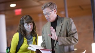 English student and professor talking in the student commons.