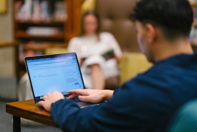 A student is focused on his laptop. 