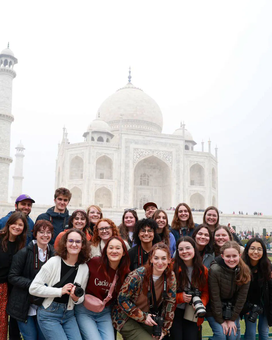 A group of students posing happily in front of the Taj Mahal during a study abroad trip.