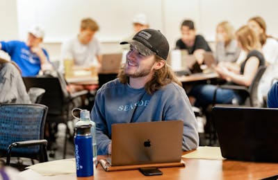 A Bethel University student smiling while engaged in a class.