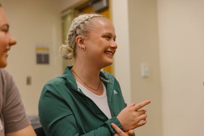 A Bethel University student smiling and participating in a classroom discussion.