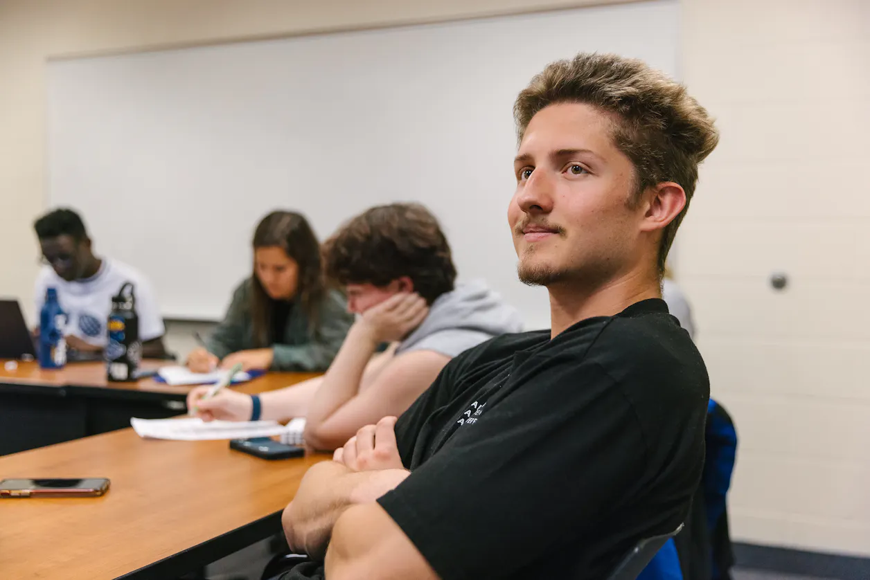 A Bethel University student smiling and participating in a classroom discussion.