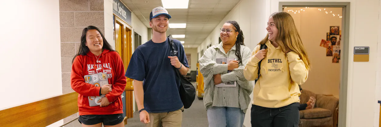 four students walking and laughing 