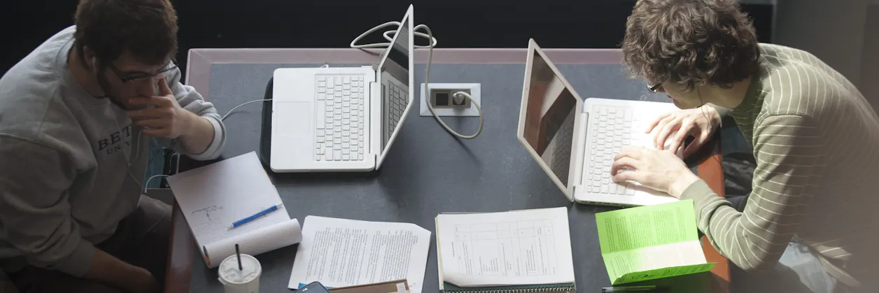 Overhead shot of students working at a table in the student commons