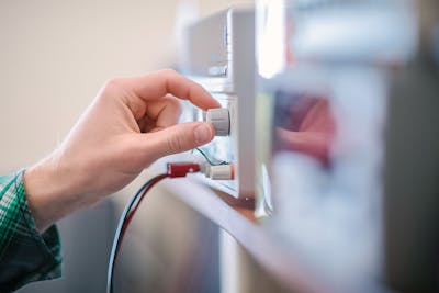 Close-up of a student adjusting equipment in a science lab at Bethel University.