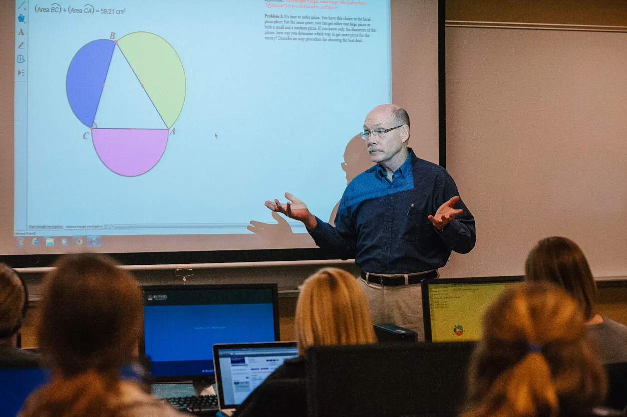Professor presenting a geometric concept to students using a projector in a math class.