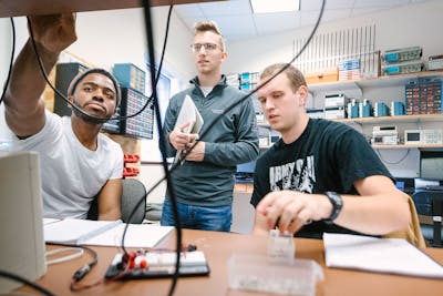 Group of students collaborating on an engineering project in a tech lab.