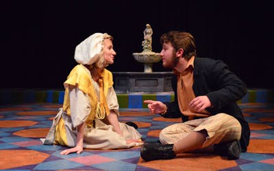 Two actors in period costumes performing a scene on stage at Bethel University, engaged in an intense dialogue.