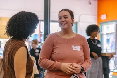 Two students engaged in a conversation, smiling, and enjoying the interaction during a class break.