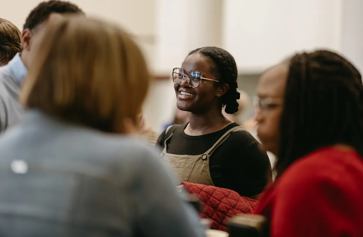 Student smiling while talking with peers during a Bethel University community gathering.