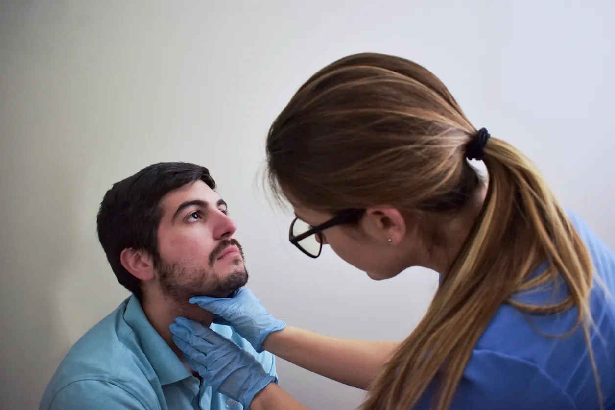 Healthcare student examining a patient’s neck during a clinical training session.