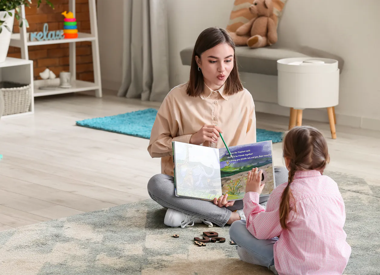 Education student reading aloud to a child during a literacy activity.