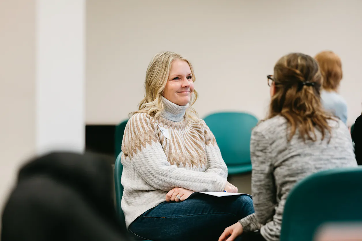 Two women smile at each other in a Bethel classroom