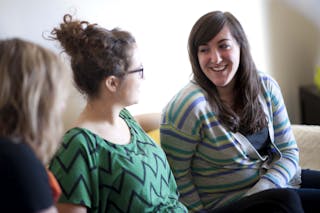 Bethel students sit on a couch in their dorm room