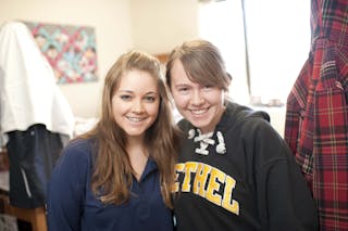 Students smile in their dorm room