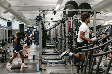 Students lift weights and run on treadmills during a workout in Bethel’s wellness center. 